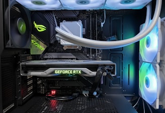 A high-end gaming or performance PC interior equipped with RGB lighting and multiple cooling fans. The graphics card prominently displayed is a GeForce RTX model, with branding visible. The setup includes neatly managed cables and a liquid cooling system.